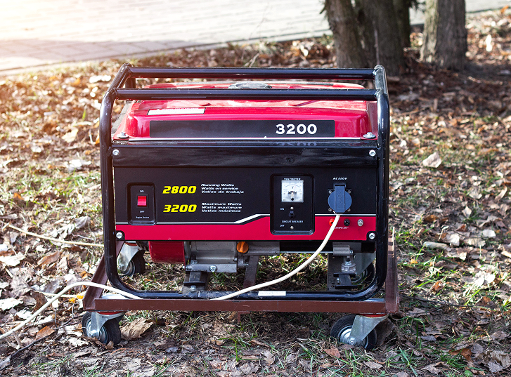Portable red 3200 generator on leaf-covered ground