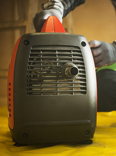 Portable generator with gloved hands nearby
